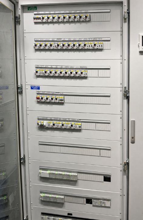 Quadro elettrico industriale aperto con file di interruttori magnetotermici