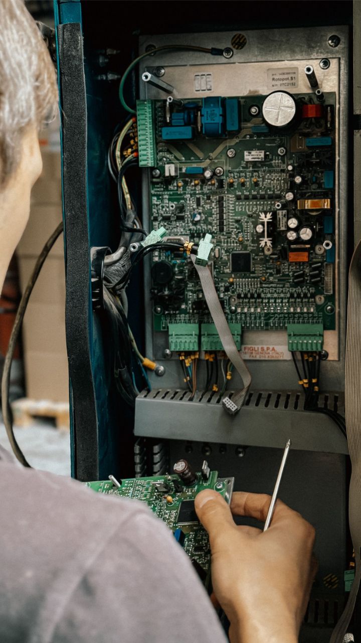 Tecnico interviene sulla centralina elettronica di un automatismo per cancelli